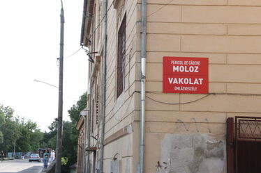 Omlásveszélyt jelző tábla a sepsiszentgyörgyi Dr. Fogolyán Kristóf Megyei Sürgősségi Kórház pszichiátriai osztályának épületén. Albert Levente felvétele