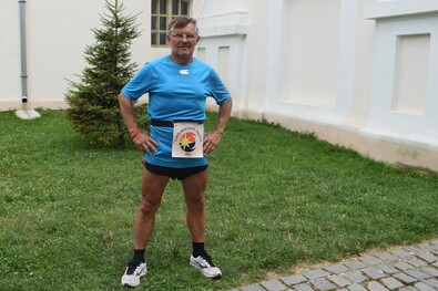 Juhos Gábor az általa ültetett fenyőfa előtt Kézdivásárhelyen.  A szerző felvétele