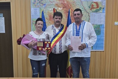 Marian Apostol egy szintén népviseletbe öltözött ifjú párral a községházán. Fotó: Facebook / Marian Apostol