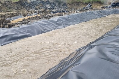  Május közepén a patak lefóliázásával próbálták kivédeni a vízbetörést, ám a fólia néhány nap alatt átszakadt. Fotó: Facebook / Parajd-Község Comuna-Praid