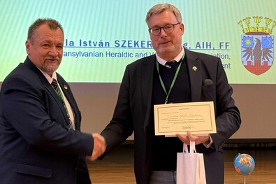 Dirk Weissleder (jobbról) átadja a köszönő oklevelet és ajándék könyvcsomagot Szekeres Attila Istvánnak. Fotó: Remigijus Bimba