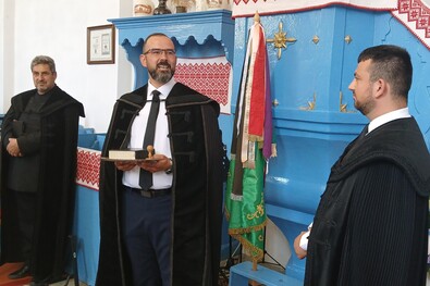 Opra Koppány lelkipásztor (jobbról) átveszi a kisbaconi egyházközség jelképeit. Fotó: Böjte Ferenc